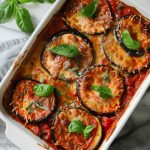 Eggplant Parmigiana, served in a white baking dish.