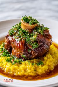 Ossobuco served with golden saffron risotto, braising sauce, and fresh lemon-parsley gremolata.