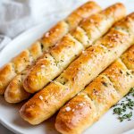 Homemade Soft Garlic Breadsticks, served on a white plate.