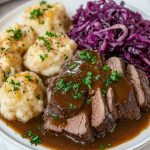 Sauerbraten, served with dumplings and red cabbage salad.