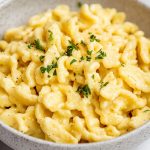Spaetzle, served in a bowl with melted butter and chopped fresh parsley.