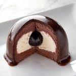 Italian Tartufo, sliced - exposing the Maraschino cherry, vanilla ice cream and chocolate ice cream inside.