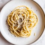 Authentic Cacio e Pepe, served on a white plate.