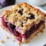 German Plum Cake (Zwetschgenkuchen) In a slice, served on a white plate.
