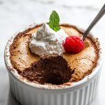 French Chocolate Soufflé topped with whipped cream and a raspberry.