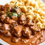 German Rahmgulasch, served with Spaetzle, on a white plate.