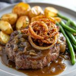 Zwiebelrostbraten (German Onion Beef Roast), served with roast potatoes and green beans.