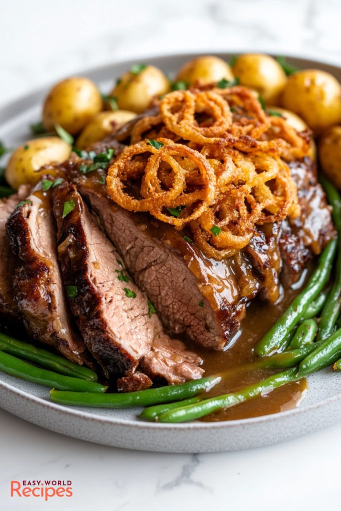 Zwiebelrostbraten Onion Beef Roast, topped with crispy onions, served with roasted potatoes and green beans.