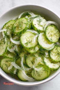German cucumber salad recipe with glossy cucumber slices, vinegar, oil, thin onion, and dill.